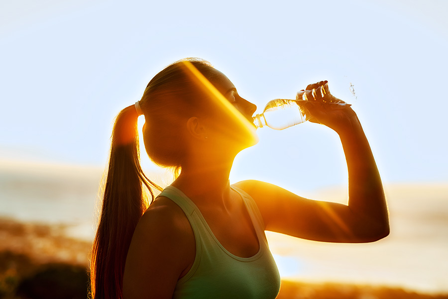 person drinking water outdoors supporting hydration and health